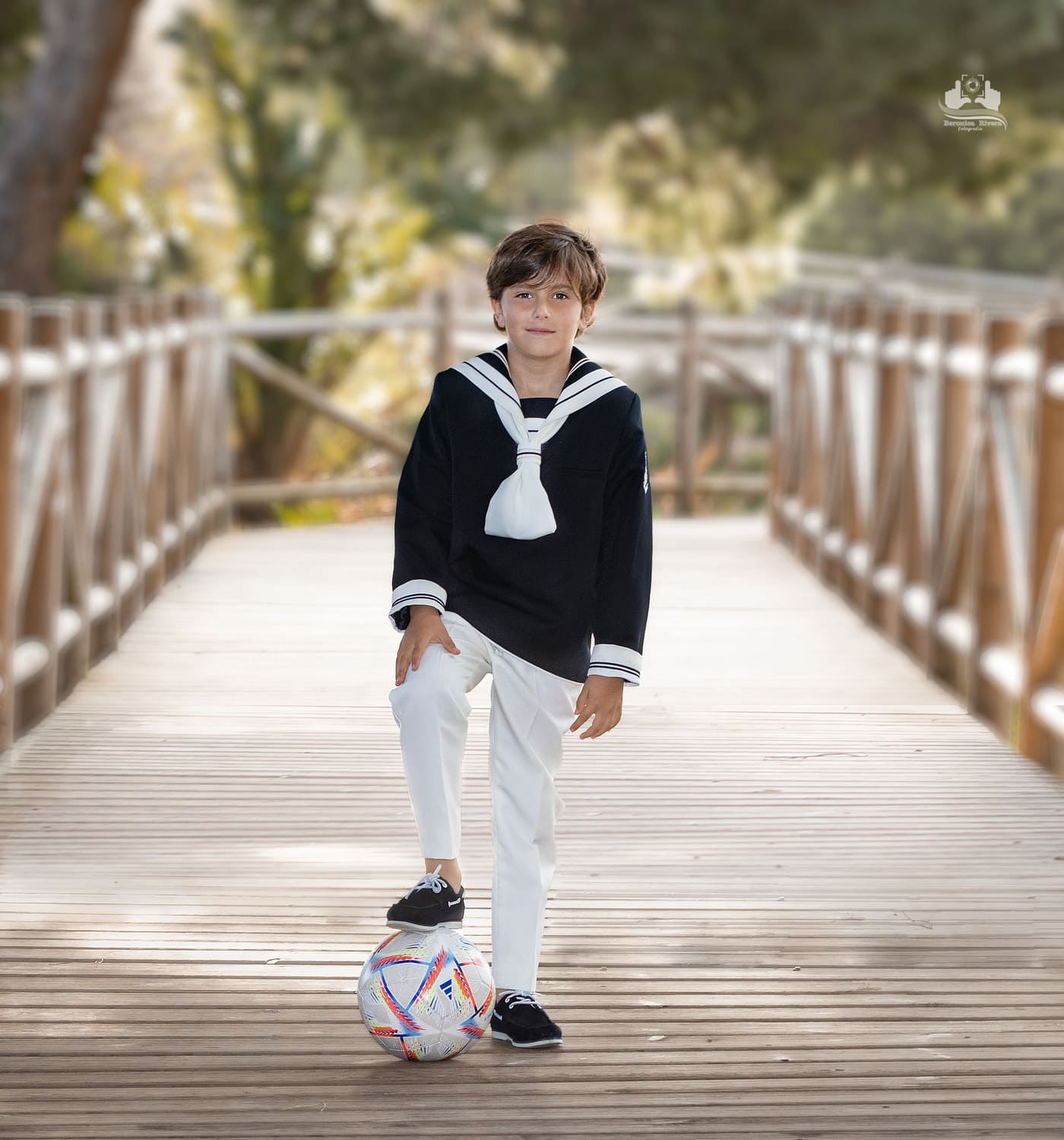 Fotografía en Fuengirola - Niño posando en el puente con su traje de comunión y un balón de fútbol